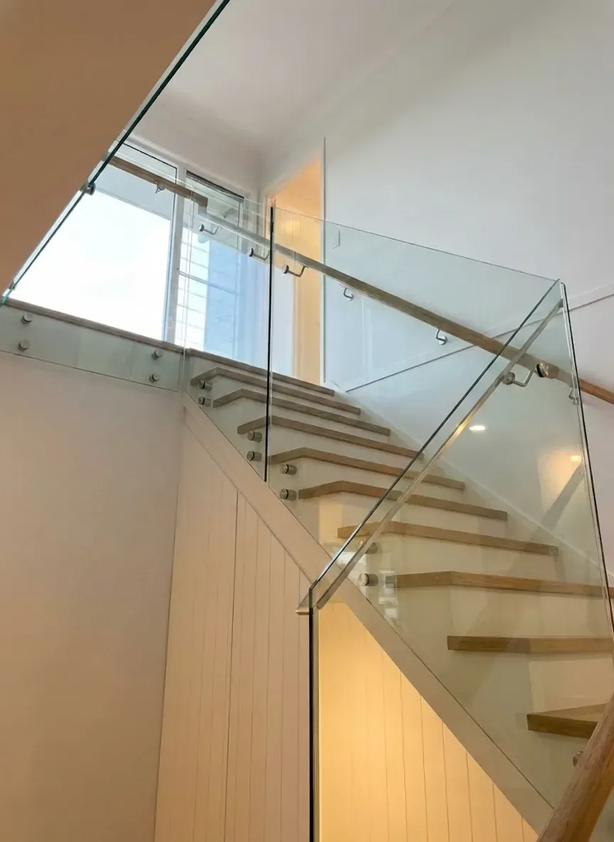 internal staircase with glass balustrade bringing light into Brisbane home